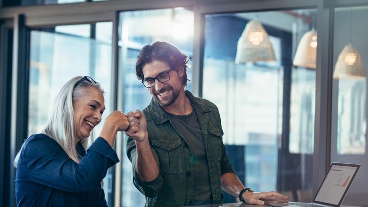 Two business people smile and fist-bump