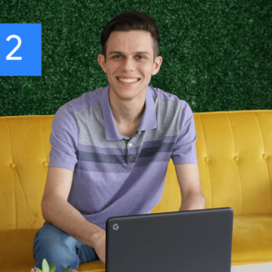 A man smiling in front of a laptop.